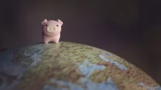 A toy pig standing on a globe